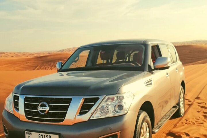 Experience the wild allure of Dubai's desert in a Nissan Patrol where adventure awaits as you conquer sand dunes and embark on unforgettable memories in the golden landscape.